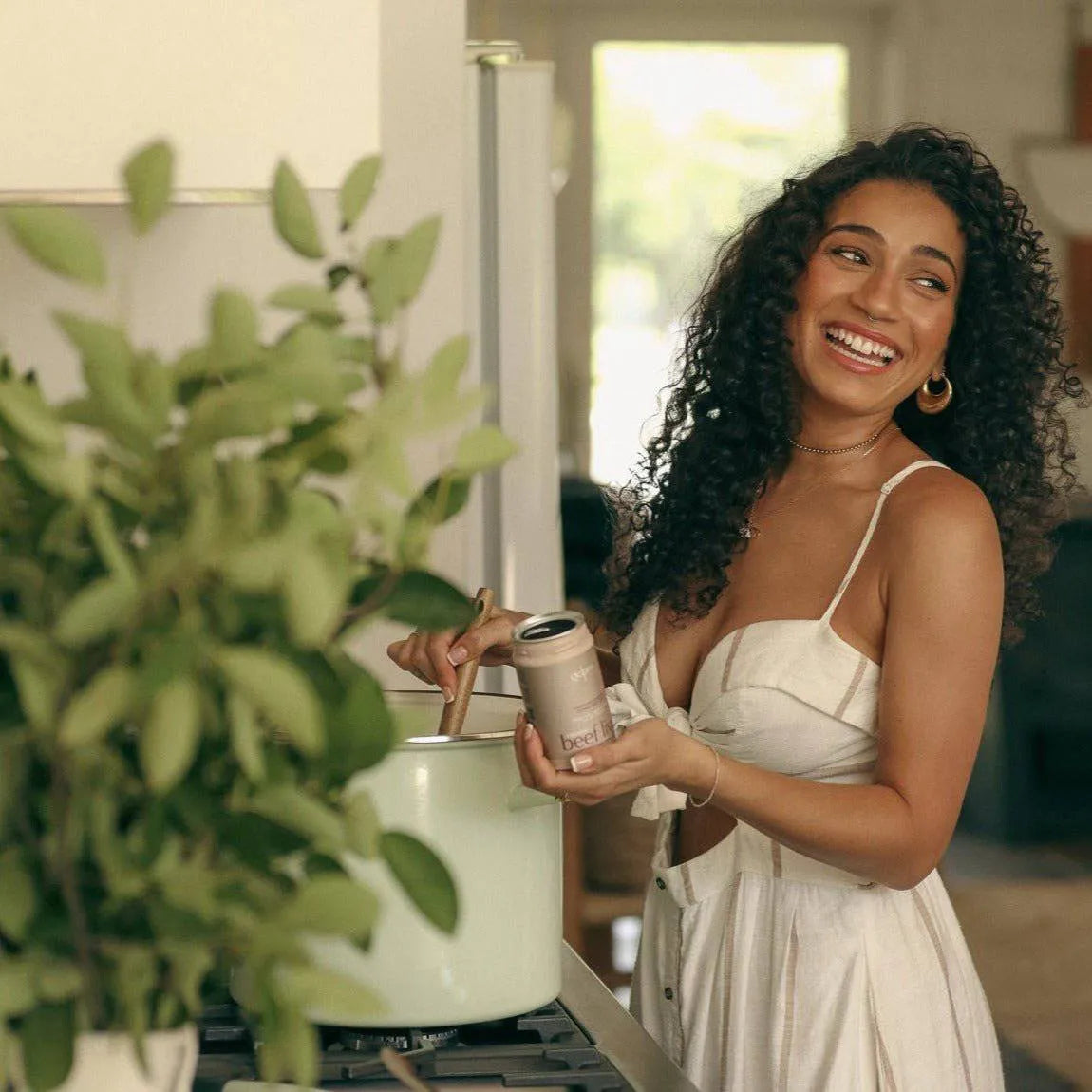 Healthy individual enjoying a collagen supplement in a bright kitchen, promoting wellness and vitality